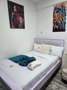 a bed in a room with a painting on the wall at ML STUDIO with Rooftop, Free wifi, Free Parking in Nakuru