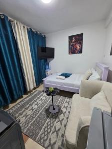 a living room with a couch and a bed at ML STUDIO with Rooftop, Free wifi, Free Parking in Nakuru