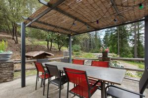 a patio with a table and chairs under a pergola at Le Mas de la Rode in Saumane