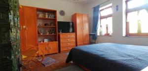 a bedroom with a bed and a dresser and a television at Casa Szatina in Kishajmás