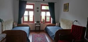 a living room with two beds and two windows at Casa Szatina in Kishajmás