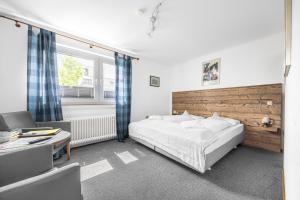 a bedroom with a large bed and a desk and a chair at Pension Domblick in Wetzlar