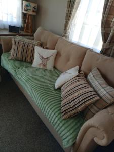 a couch with pillows on it in a living room at 75 Orchard Mount, 3 bed luxury caravan Skirlington- sleeps 6 in Hornsea