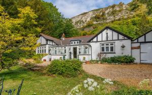 a large white house with a mountain in the background at Undercliff View - St Lawrence Retreat in Saint Lawrence