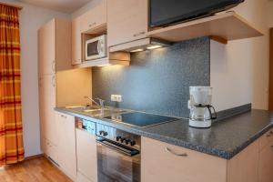 a kitchen with a sink and a counter top at Ferienwohnung Schretthauser in Bad Mitterndorf +2 photos