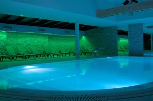 a swimming pool in a building with chairs at Résidence Les Cigogneaux in Ostheim