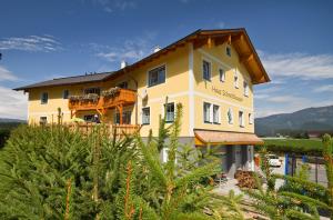 a large yellow building with a balcony on top at Ferienwohnung Schretthauser in Bad Mitterndorf
