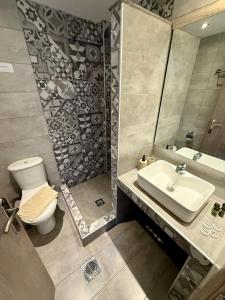 a bathroom with a sink and a toilet and a mirror at ΑVLI Sarti Studios & Apartments no 3 in Sarti +9 photos