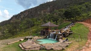 a water park with a waterfall and a water slide at Pousada Carraro in Delfinópolis +5 photos