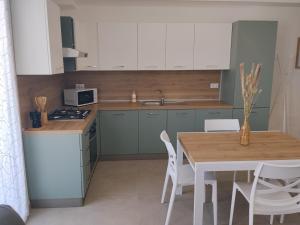 a kitchen with a wooden table and white cabinets at Venice Delta Lagoon Apartments in Porto Viro
