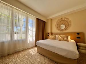 a bedroom with a large bed and a large window at Hôtel & Résidence Vacances Bleues Orhoïtza in Hendaye +71 photos