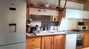 a kitchen with a white refrigerator and a sink at gîte l'écureuil roux in LʼArgentière-la-Bessée