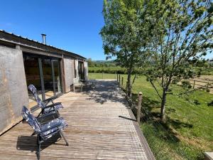 two benches sitting on a wooden walkway next to a building at Meadows - Eco Retreat in Bitton