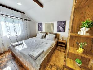 a bedroom with a large bed with wooden walls at Apartman Dve lipe in Palić