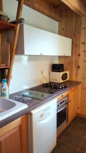 a kitchen with a stove top oven next to a sink at gîte l'écureuil roux in LʼArgentière-la-Bessée