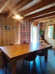 a dining room with a wooden table and chairs at gîte l'écureuil roux in LʼArgentière-la-Bessée +26 photos