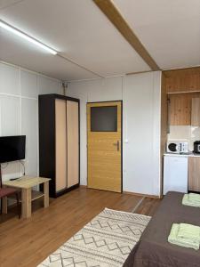 a room with a television and a table and a kitchen at Микрон in Zatoka
