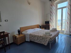 a bedroom with a bed and a large window at Albergo Bandoni in Rapallo