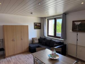 a living room with a couch and a table at Pension Luzia in Oberhof