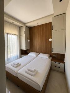 a bedroom with a large bed with two towels on it at Olea Stone Houses in Bodrum City +6 photos