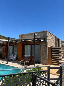 a villa with a swimming pool and a house at Olea Stone Houses in Bodrum City
