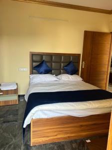 a bedroom with a large bed with blue pillows at Sri Sai royal suites in Sonda