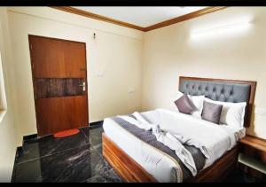 a bedroom with a large bed with a wooden headboard at Sri Sai royal suites in Sonda