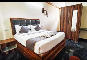 a bedroom with a large bed with a wooden frame at Sri Sai royal suites in Sonda