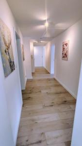 an empty hallway with wood floors and paintings on the walls at Penthouse am Kurparkweiher in Bad Schwalbach +34 photos
