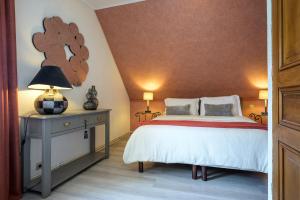 a bedroom with a bed and a table with a lamp at Chez Noëlle - Piscine in Sélestat +23 photos