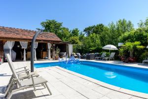 a swimming pool with a chair and an umbrella at Chez Noëlle - Piscine in Sélestat