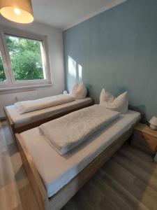 two beds in a room with a window at Monteurwohnungen Bad Langensalza in Bad Langensalza