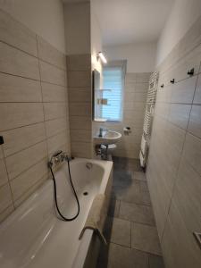 a bathroom with a bath tub and a sink at Monteurwohnungen Bad Langensalza in Bad Langensalza +49 photos