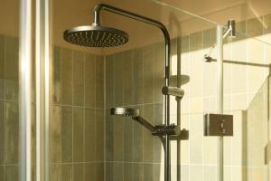 a shower with a shower head in a bathroom at Gezeiten Suites Büsumer Deichhausen - Neueröffnung in Büsumer Deichhausen +15 photos