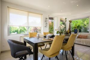 a dining room with a black table and yellow chairs at Chez Noëlle - Piscine in Sélestat