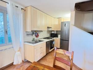 a kitchen with wooden cabinets and a stainless steel refrigerator at 4VENTI by LigurianLife in Vallebona +9 photos