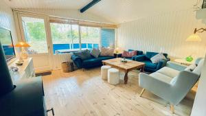 a living room with blue couches and a table at Cottage Near Forest And Beach in Glesborg