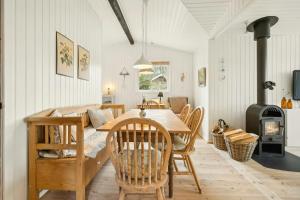 a dining room with a table and chairs and a fireplace at Cottage Near Forest And Beach in Glesborg