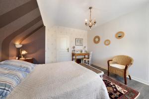 a bedroom with a bed and a desk and a chair at Chambres D'hôtes Kergollay in Lanhouarneau