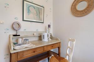 a dressing table in a room with a mirror at Chambres D'hôtes Kergollay in Lanhouarneau +33 photos