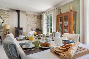a breakfast table with bread and croissants on it at Chambres D'hôtes Kergollay in Lanhouarneau