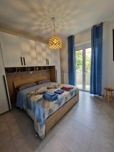 a bedroom with a bed and a chandelier at Alis home 100 mt dal mare in Loano