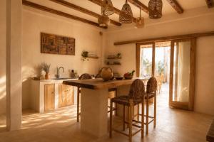 a kitchen with a large wooden table and chairs at Villa Kampung in Gili Islands