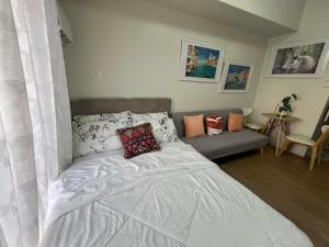 a bedroom with a bed and a couch at Loop Towers by Vista Residences in Pontud