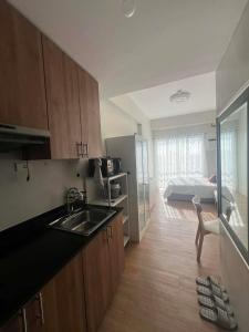 a kitchen with a sink and a room with a bed at Loop Towers by Vista Residences in Pontud