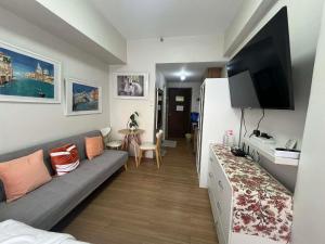 a living room with a couch and a flat screen tv at Loop Towers by Vista Residences in Pontud