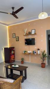 a living room with a table and a tv at Trayi stay in Mysore