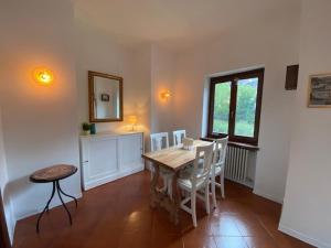 a dining room with a wooden table and chairs at Sul fiume di Varallo in Varallo