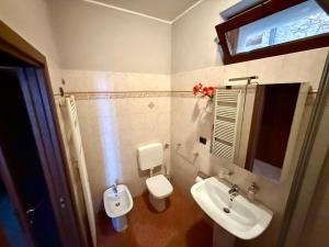 a bathroom with a toilet and a sink at Lake's Sound in Nesso +18 photos