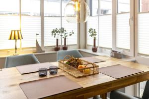 a dining room table with a basket of fruit on it at Pier17 Appartement 2 in Borkum